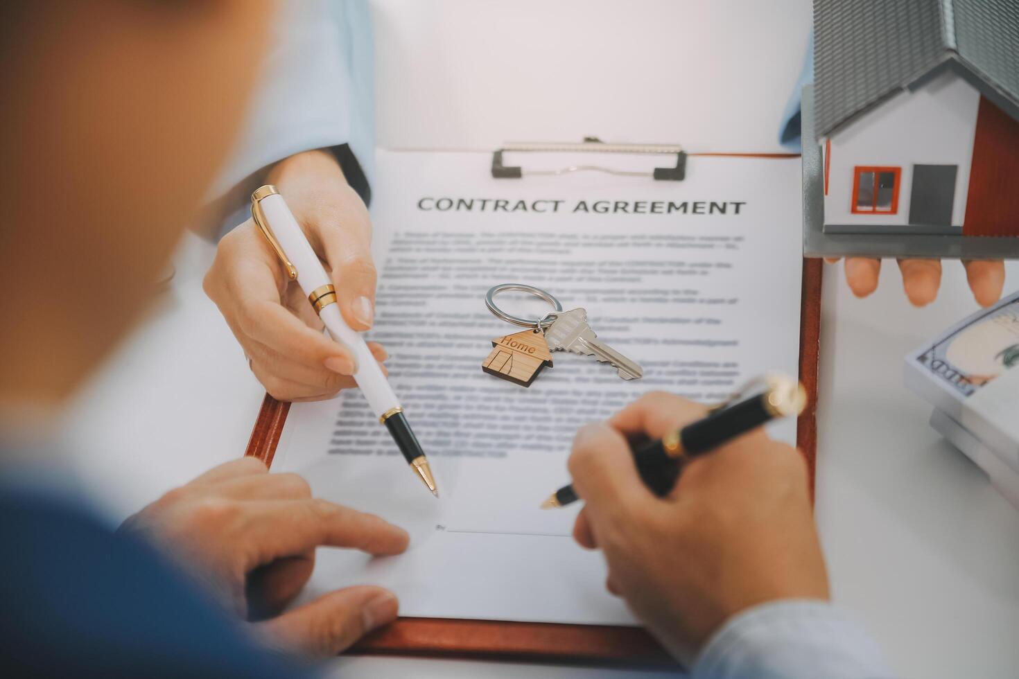 Real estate agent talked about the terms of the home purchase agreement and asked the customer to sign the documents to make the contract legally, Home sales and home insurance concept. photo