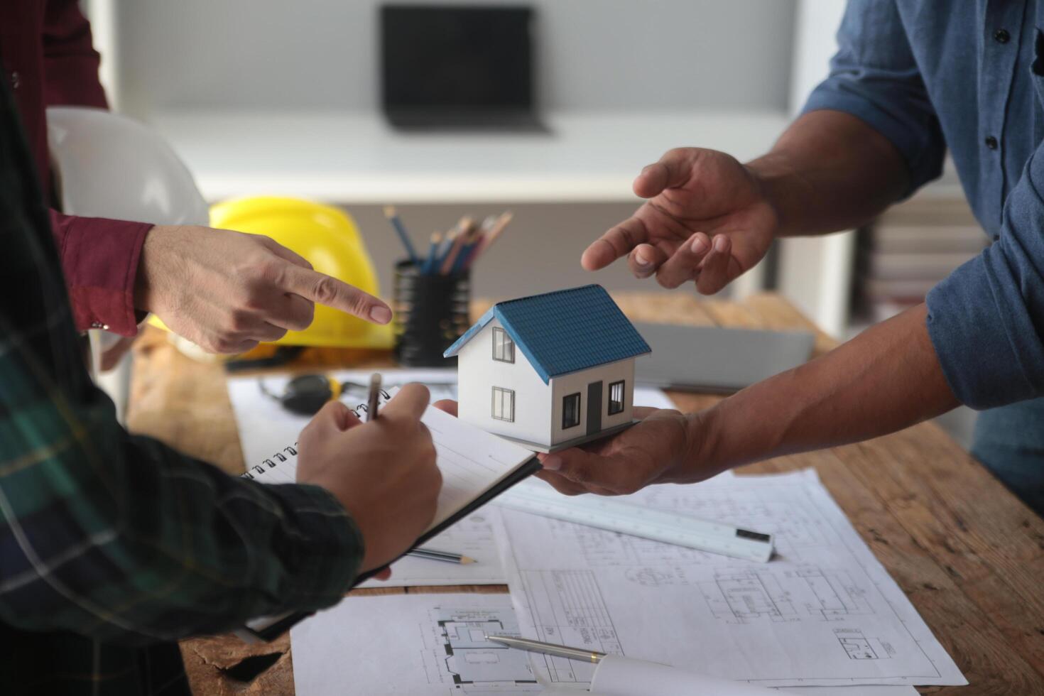 Engineers are consulting the team to design an architectural structure for clients with blueprints and building models to work at office. photo