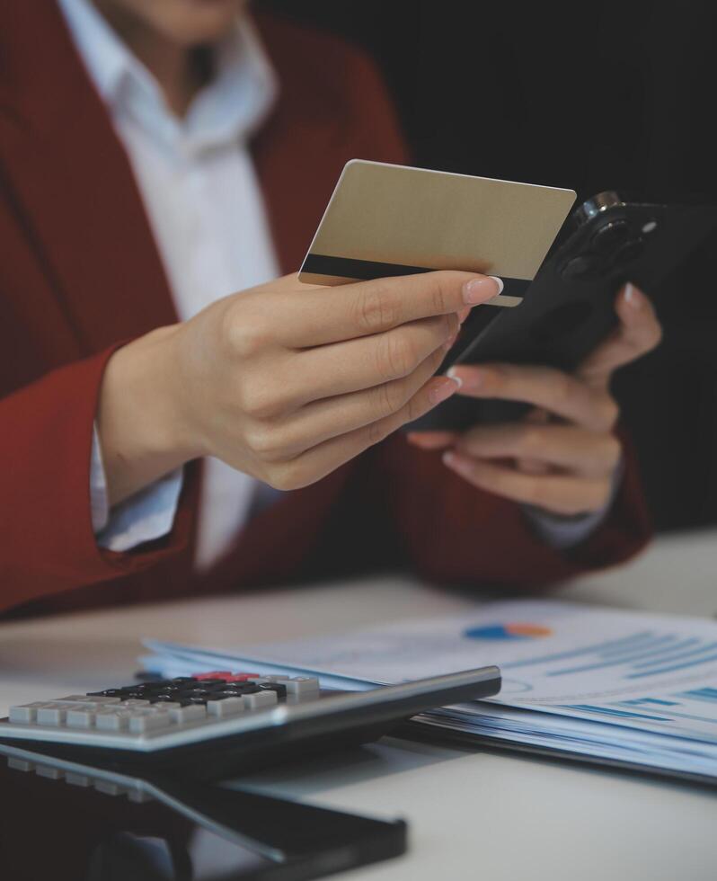 mano participación crédito tarjeta y utilizando ordenador portátil. mujer de negocios o empresario trabajando desde hogar. en línea compras, comercio electrónico, Internet bancario, gasto dinero, trabajo desde hogar concepto foto