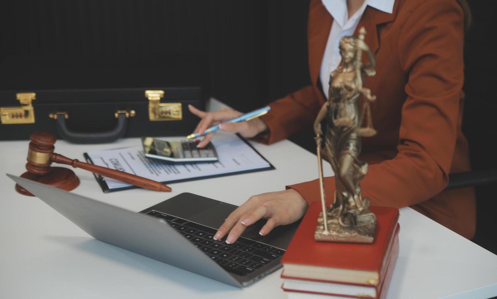 American woman lawyer or businesswoman African working with laptop, searching, analyzing data, reading contract documents work with law books hammer of justice Consulting lawyer concept. photo