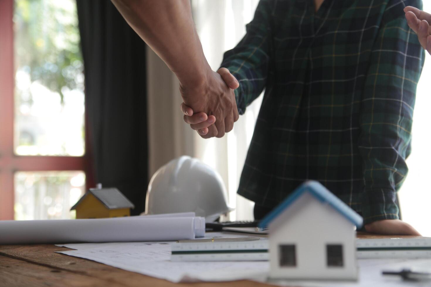 Engineer and contractor join hands after signing contract,They are having a modern building project together. successful cooperation team concept photo