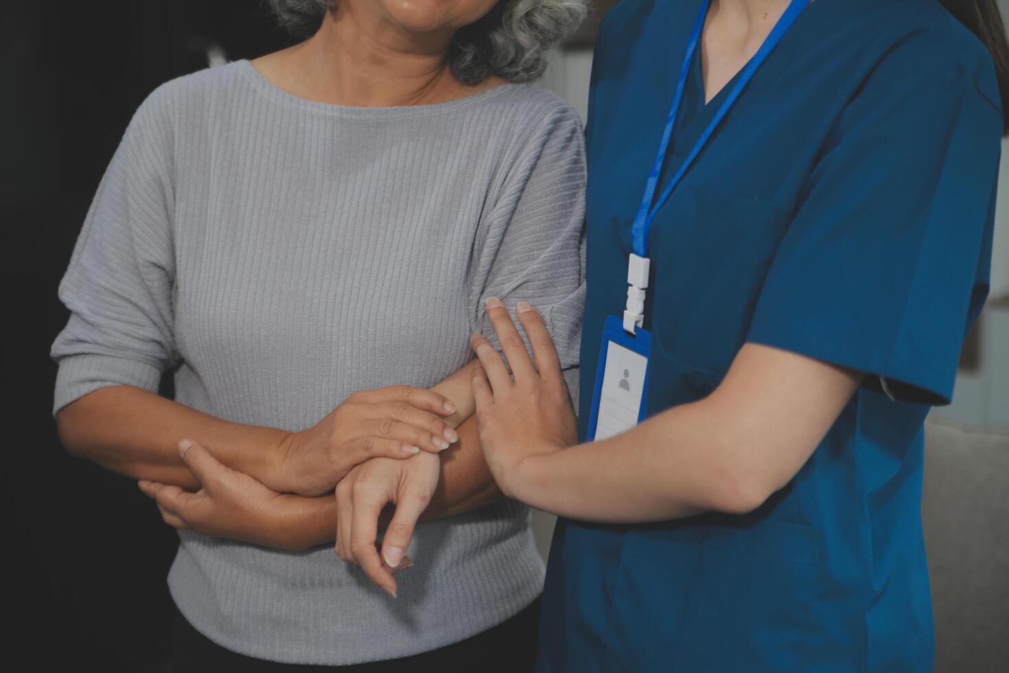 Female caregiver doing regular check-up of senior woman in her home. photo