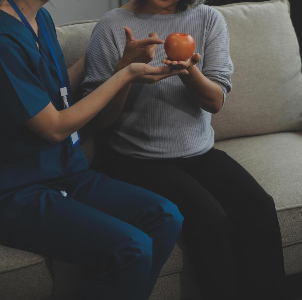 Happy young female nurse provide care medical service help support smiling old grandma at homecare medical visit, lady carer doctor give empathy encourage retired patient sit on sofa at home hospital photo