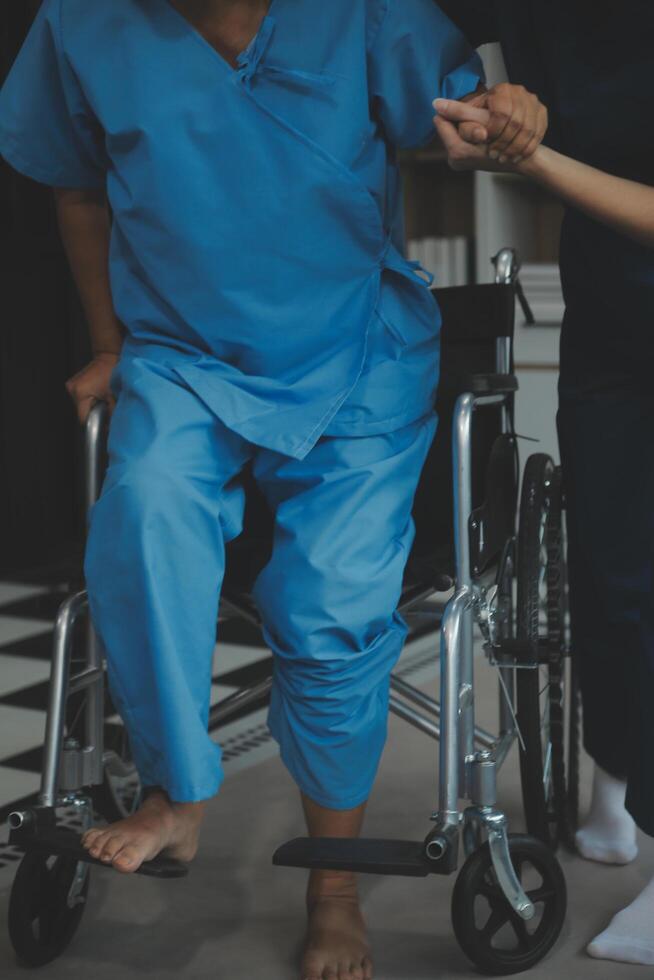 Doctor giving hope. Close up shot of young female physician leaning forward to smiling elderly lady patient holding her hand in palms. Woman caretaker in white coat supporting encouraging old person photo