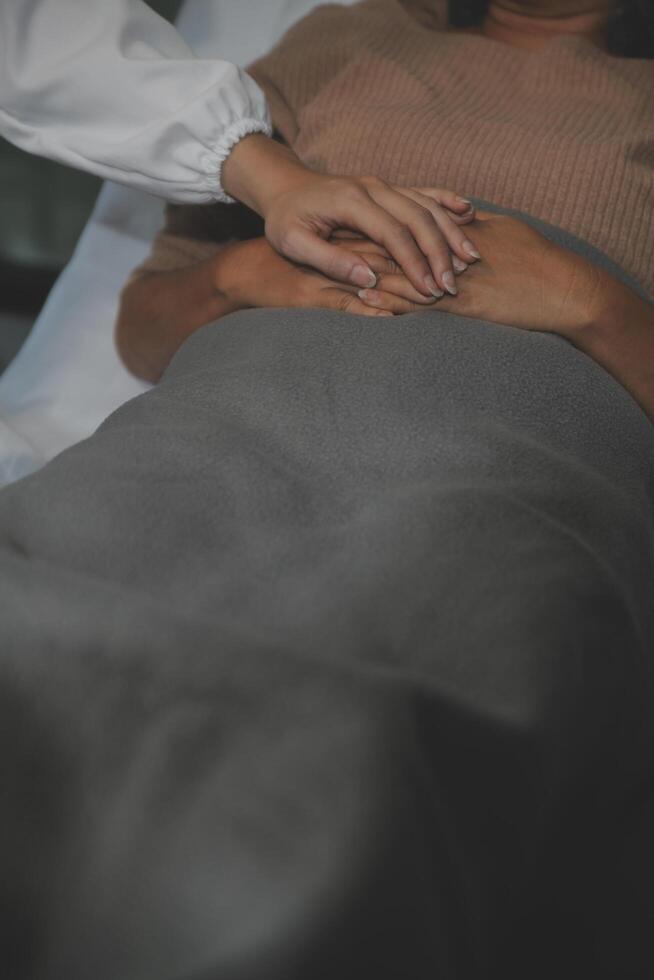 Cropped shot of a female nurse hold her senior patient's hand. Giving Support. Doctor helping old patient with Alzheimer's disease. Female carer holding hands of senior man photo