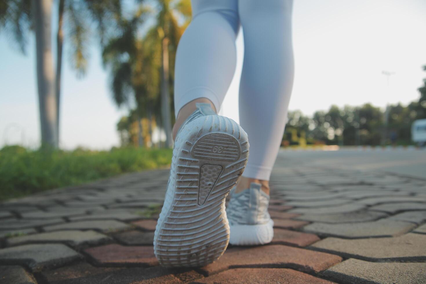 Young fitness woman runner stretching legs before run on city photo