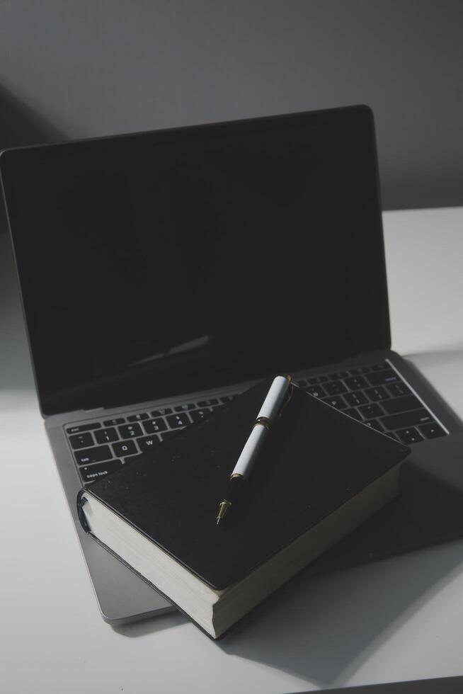 Office workplace with text space, White wooden table with office supplies tablet, desktop computer and book, top view, over light photo