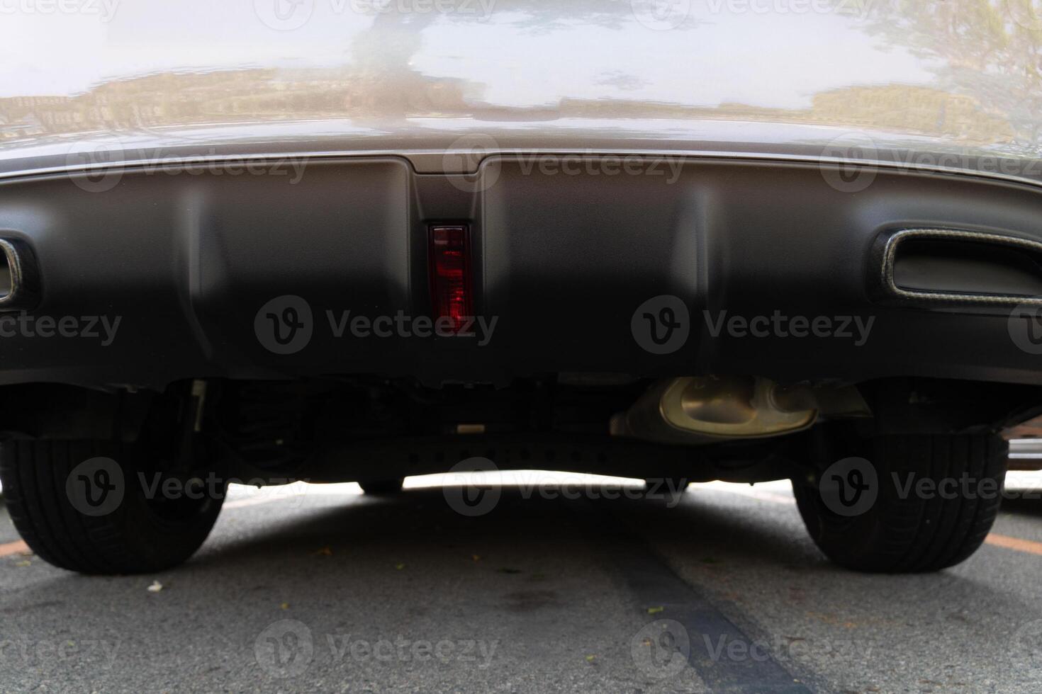 Detail of the rear bumper of a vintage car on the asphalt road. Car in the parking lot. photo