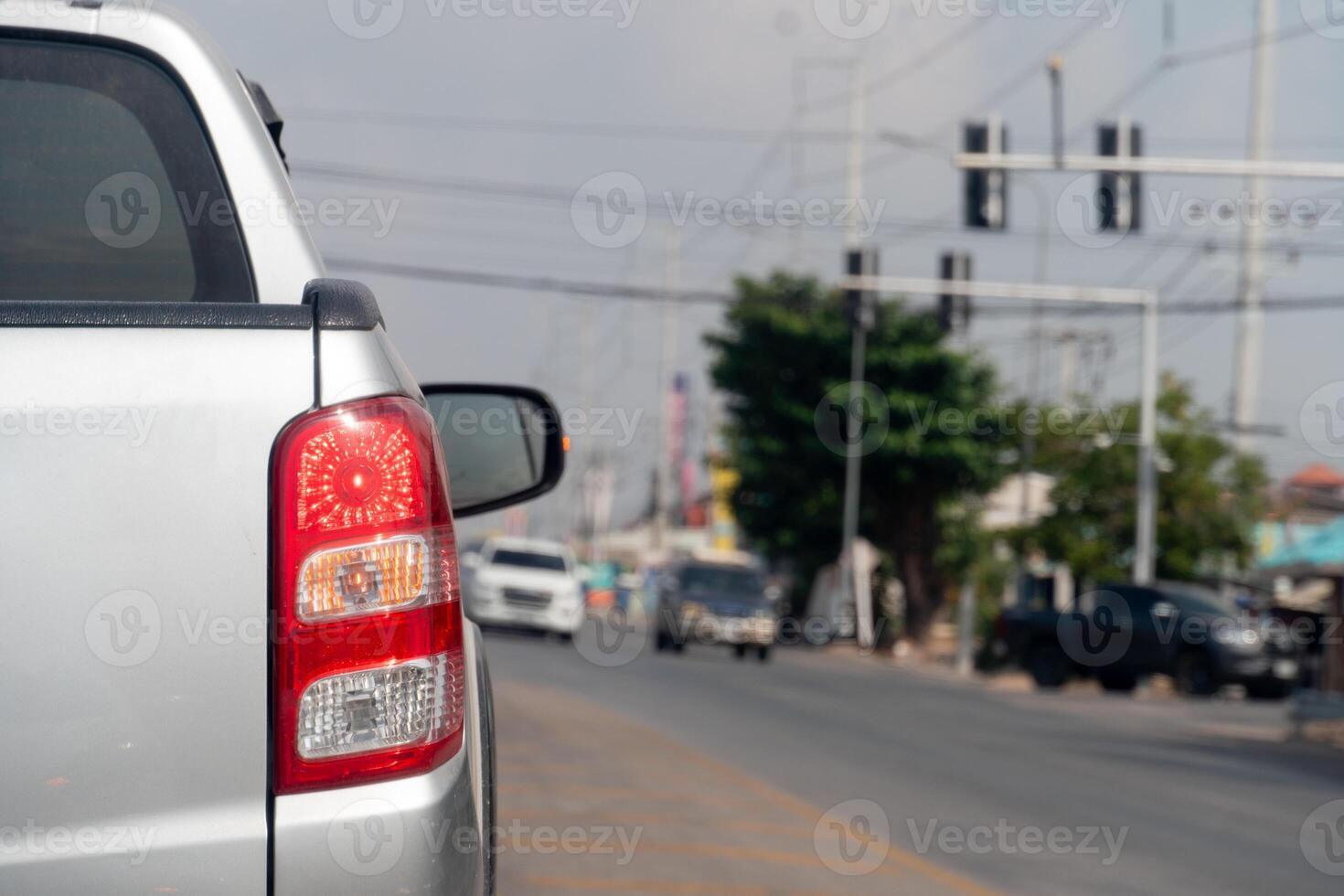 Pickup car silver color on the road stop and turn on brake light. Traffic light on the road. Blur image of traffic jam. photo