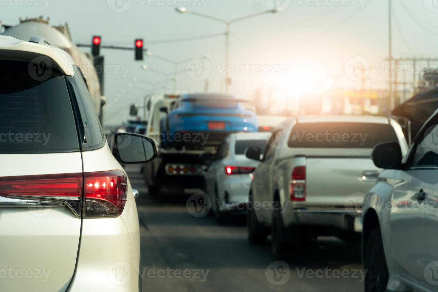 Luxury of white car stop on the asphalt road. Traveling in the provinces during on day. Open light brake in the city. Traffic jam after to work in an urban area. photo