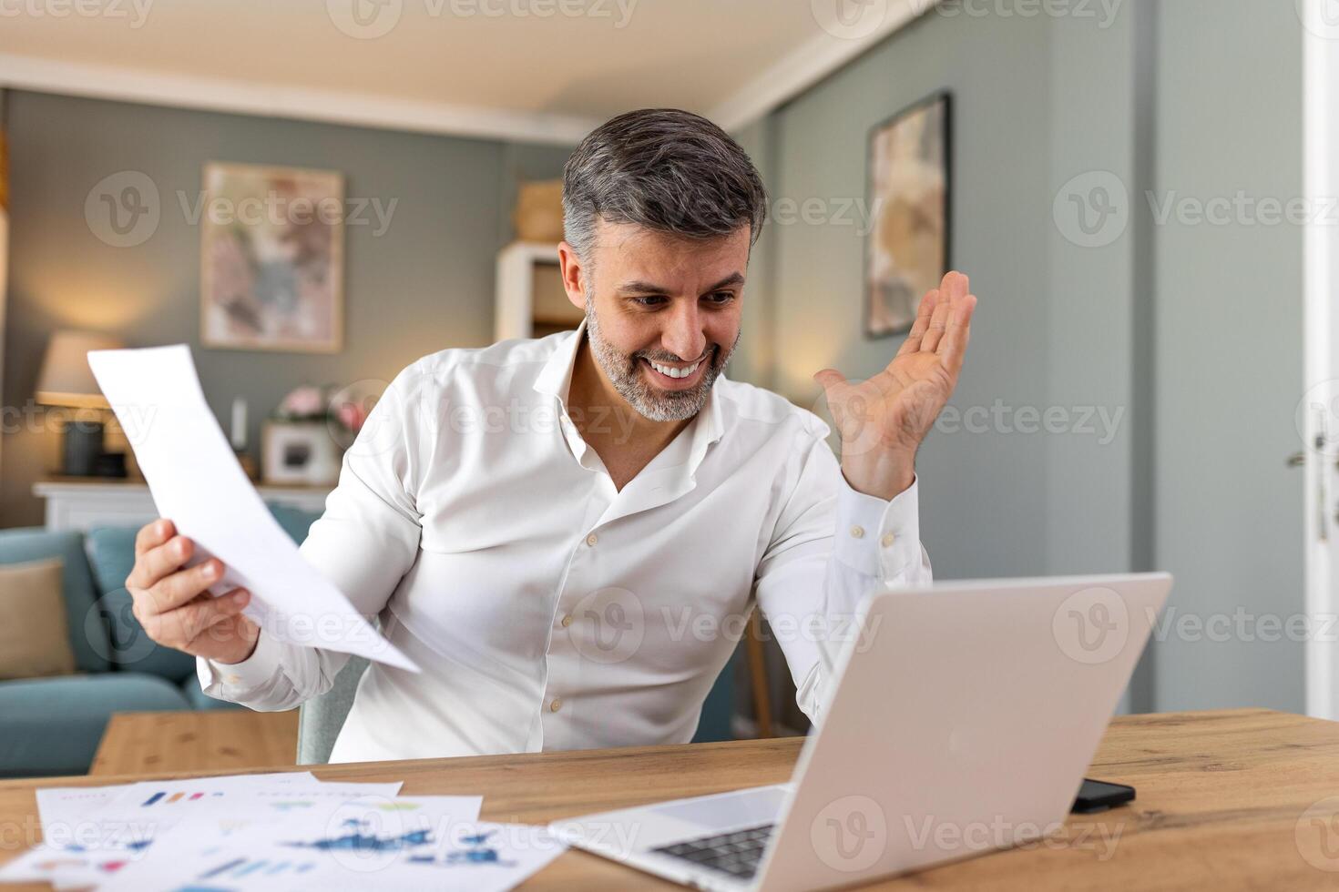 Handsome man working on laptop. Business man busy working on laptop computer at office. Businessman sitting at bright modern work station and typing on laptop photo