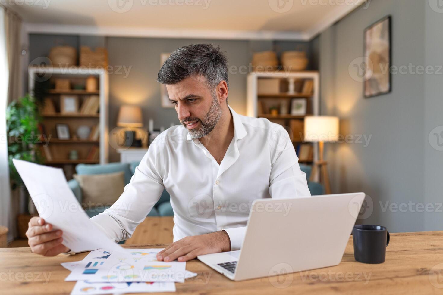 Business professionals. Business man analyzing data using computer while spending time in the office. Young grinning professional man in office. Graphs and charts photo