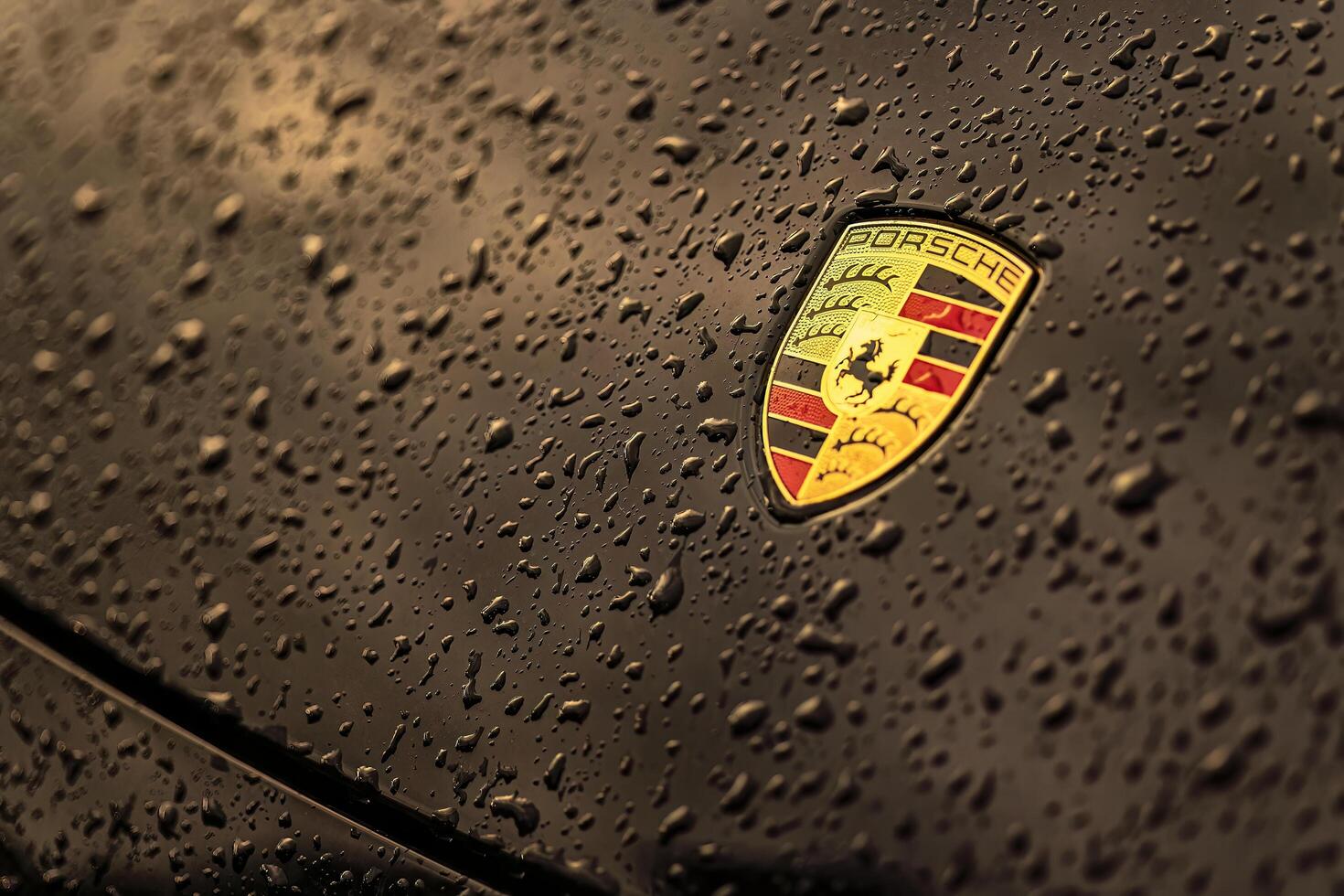 Masi Italy 7 june 2023 Close up photo of a black car featuring the iconic Porsche emblem and water droplets