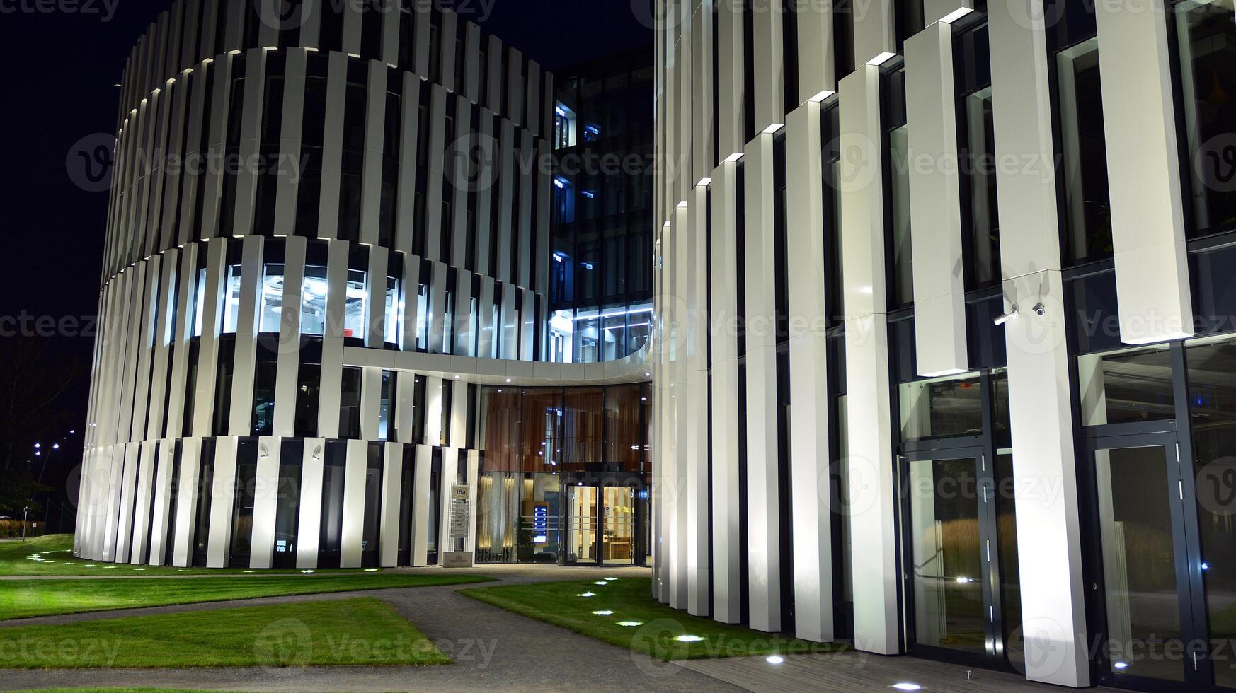 Pattern of office buildings windows illuminated at night. Glass architecture ,corporate building at night - business concept. photo