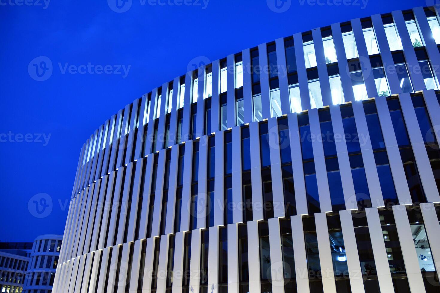 Pattern of office buildings windows illuminated at night. Glass architecture ,corporate building at night - business concept. photo