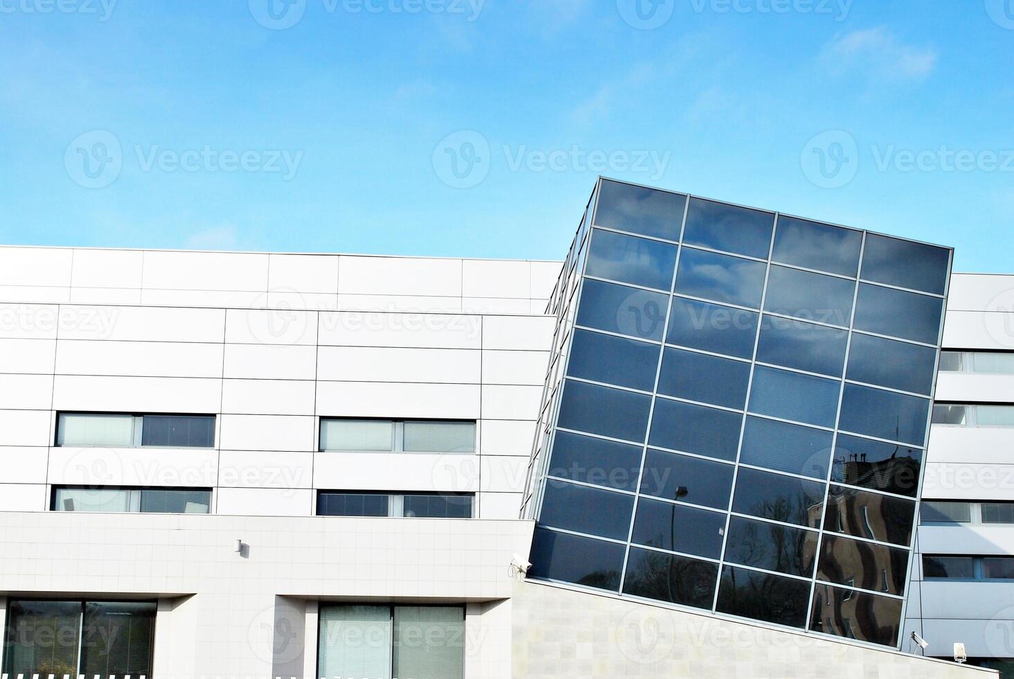 Structural glass wall reflecting blue sky. Abstract modern architecture fragment photo