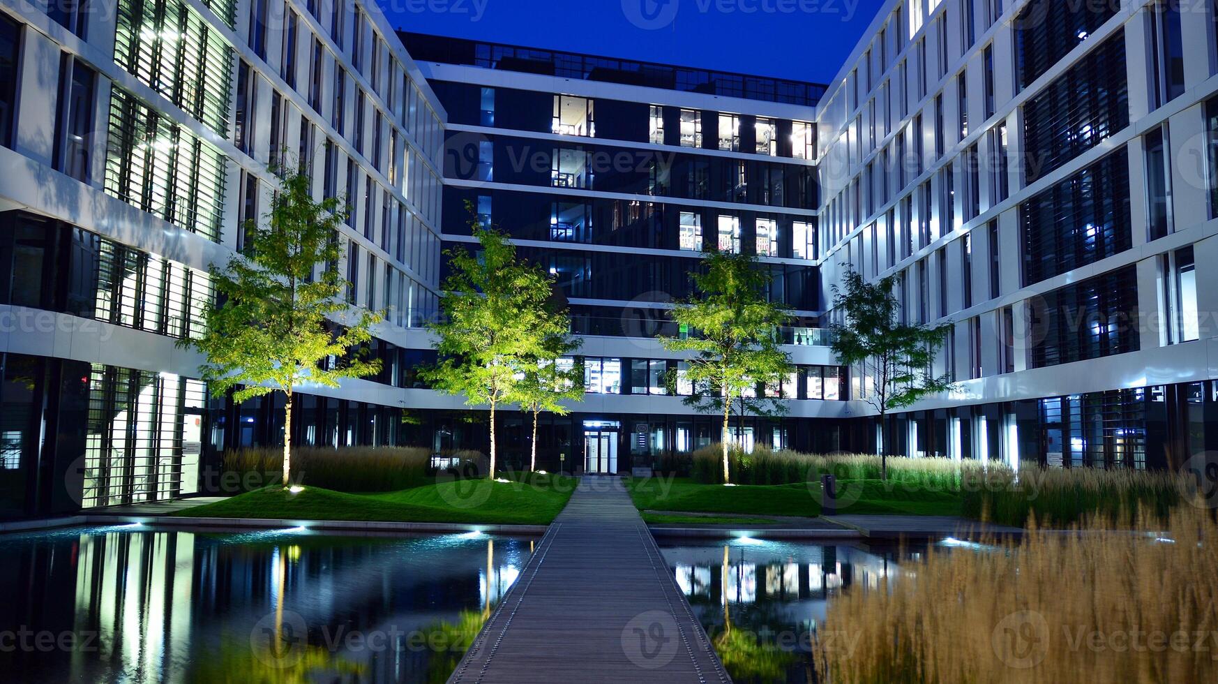 Pattern of office buildings windows illuminated at night. Glass architecture ,corporate building at night - business concept. photo