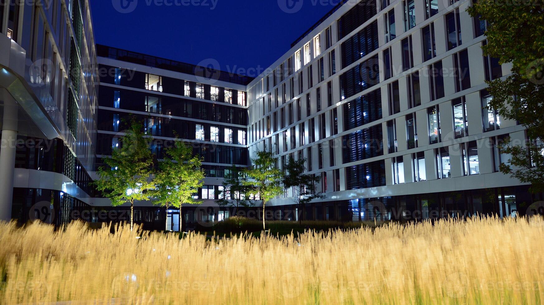 Pattern of office buildings windows illuminated at night. Glass architecture ,corporate building at night - business concept. photo