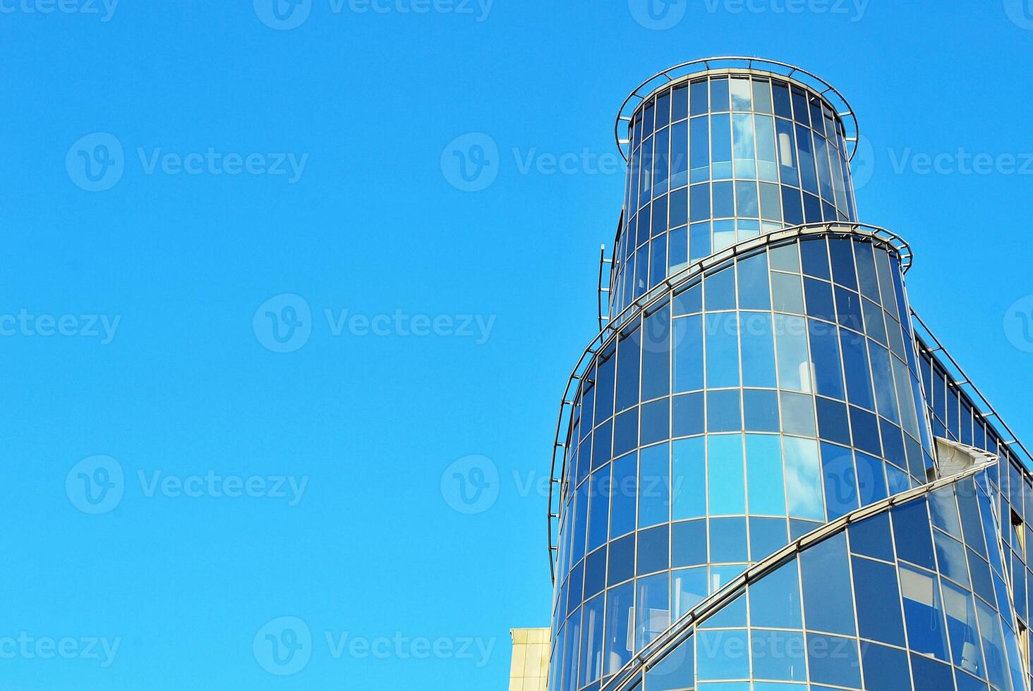 Structural glass wall reflecting blue sky. Abstract modern architecture fragment photo