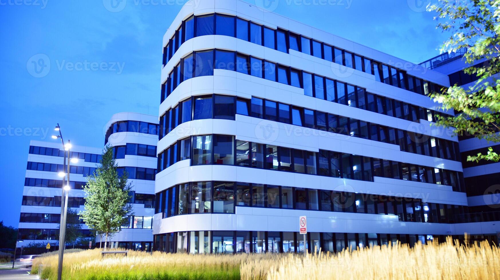Pattern of office buildings windows illuminated at night. Glass architecture ,corporate building at night - business concept. photo