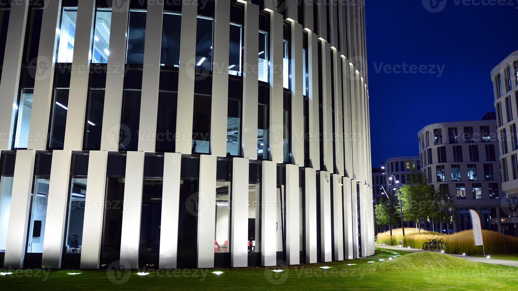 Pattern of office buildings windows illuminated at night. Glass architecture ,corporate building at night - business concept. photo