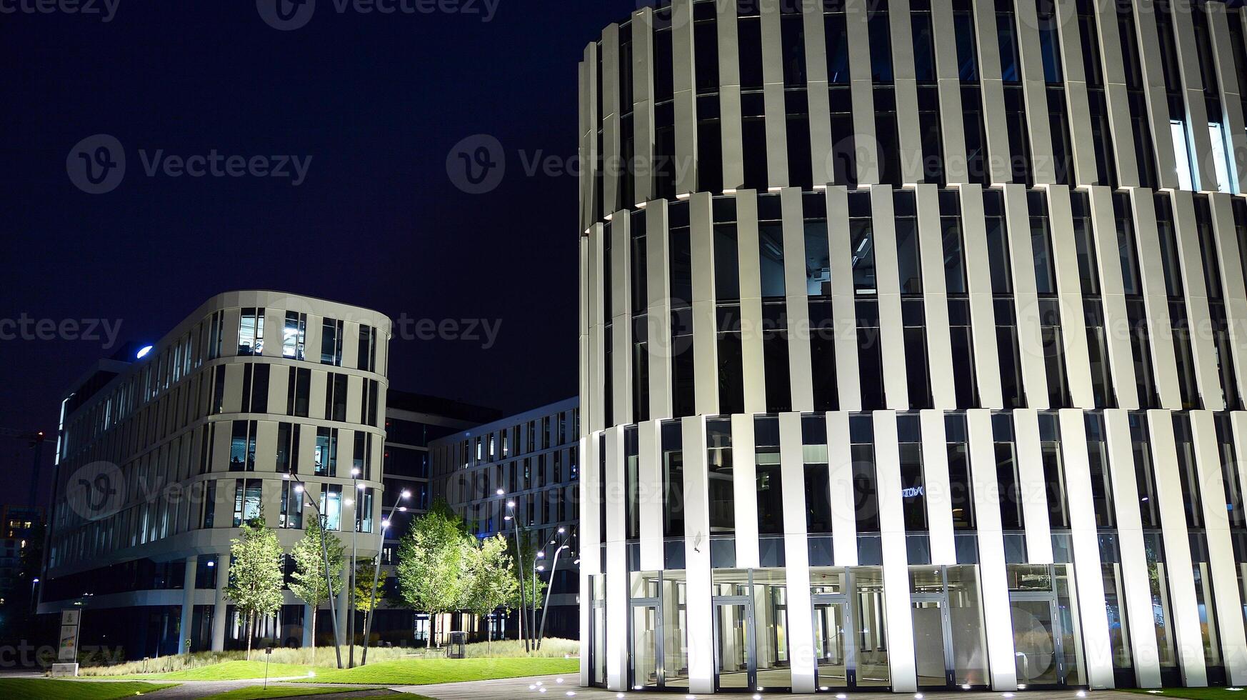 Pattern of office buildings windows illuminated at night. Glass architecture ,corporate building at night - business concept. photo