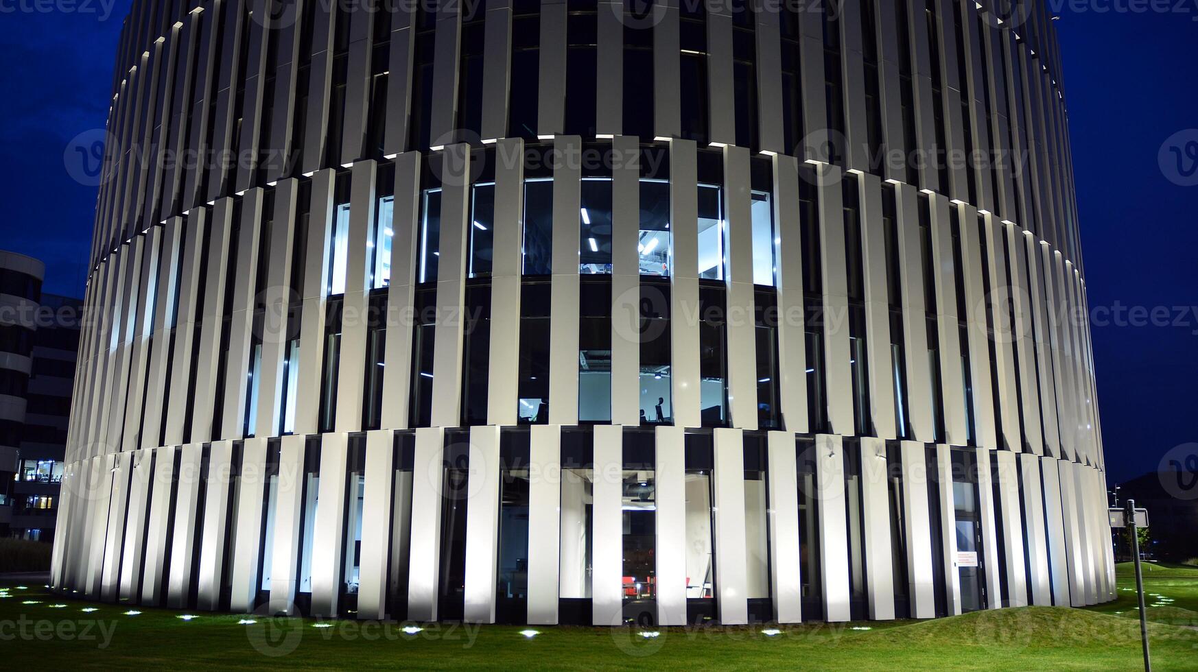 Pattern of office buildings windows illuminated at night. Glass architecture ,corporate building at night - business concept. photo