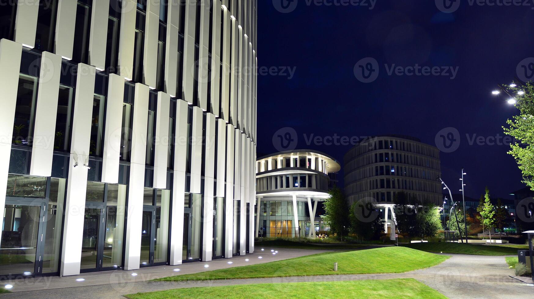 Pattern of office buildings windows illuminated at night. Glass architecture ,corporate building at night - business concept. photo