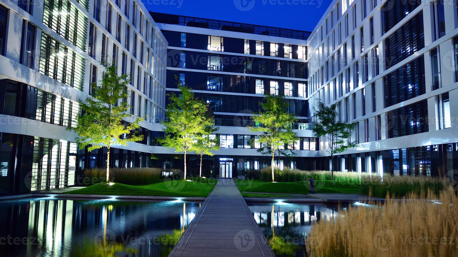 Pattern of office buildings windows illuminated at night. Glass architecture ,corporate building at night - business concept. photo