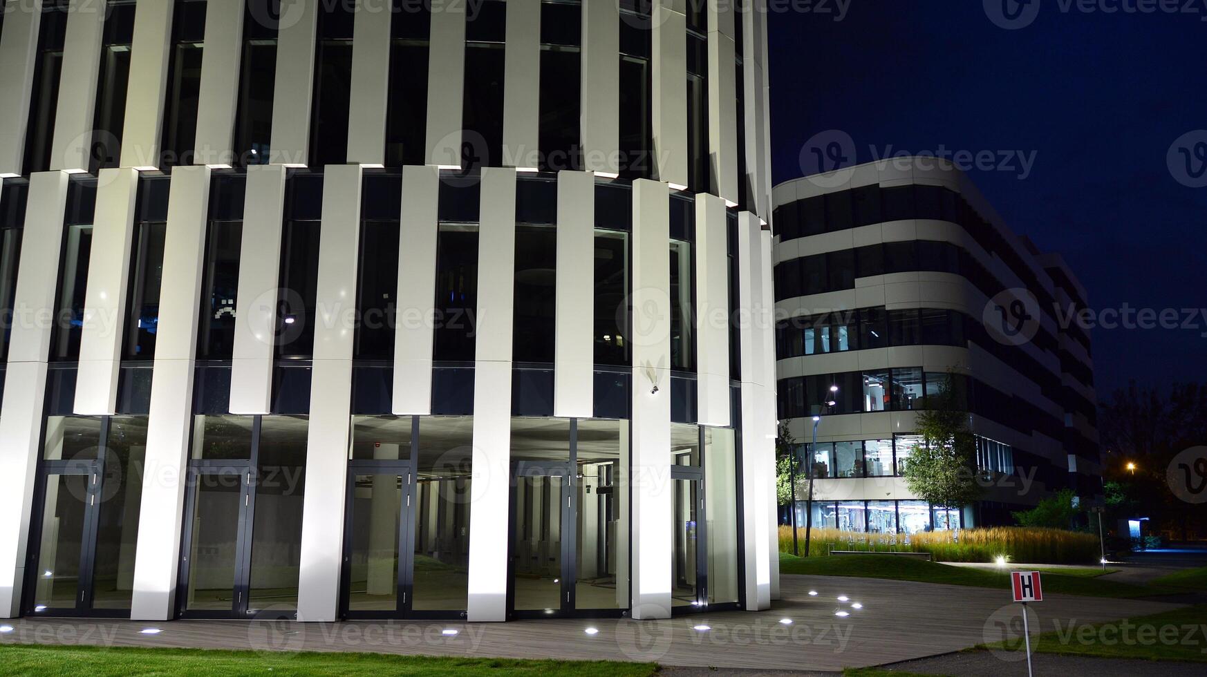 Pattern of office buildings windows illuminated at night. Glass architecture ,corporate building at night - business concept. photo