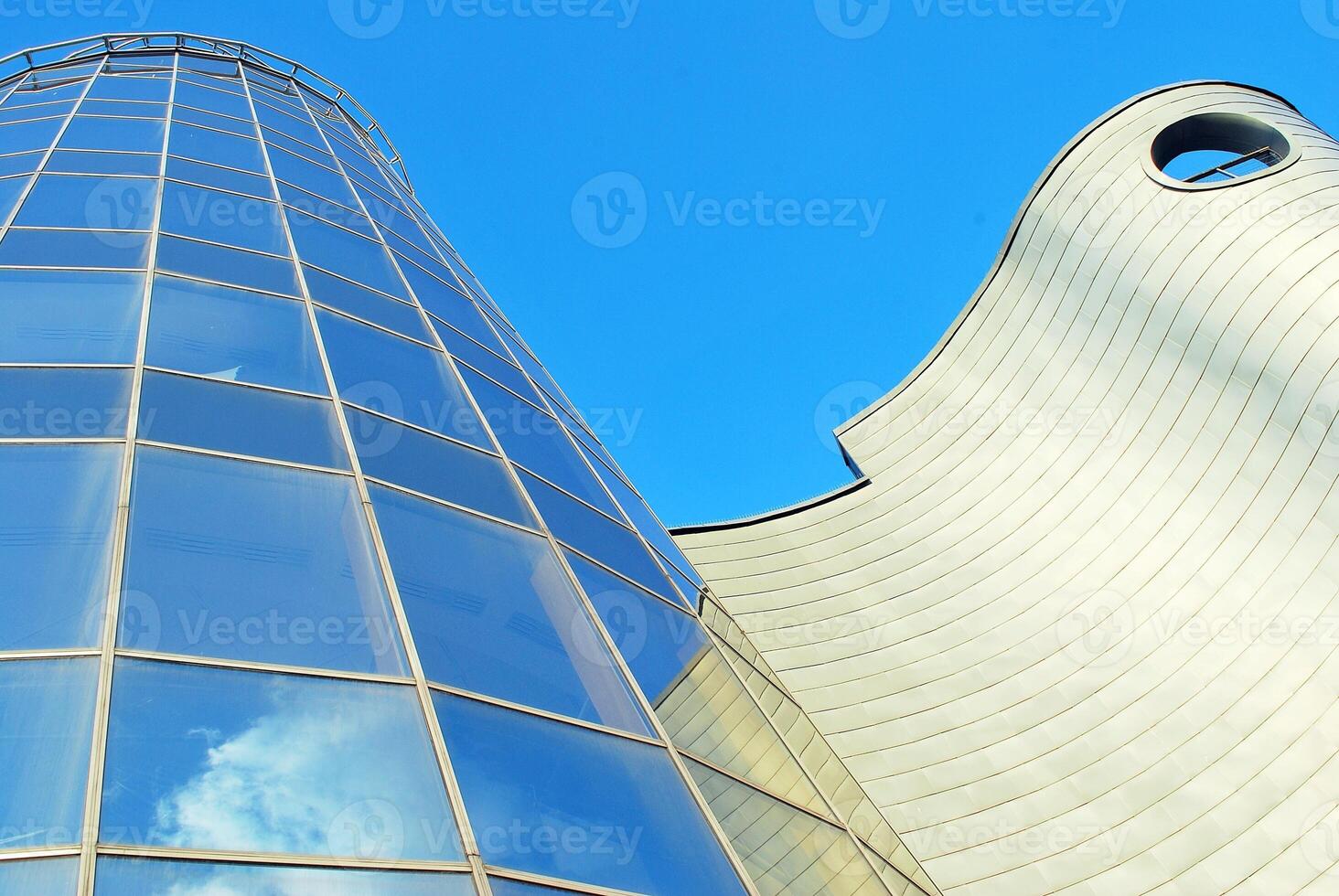 Structural glass wall reflecting blue sky. Abstract modern architecture fragment photo