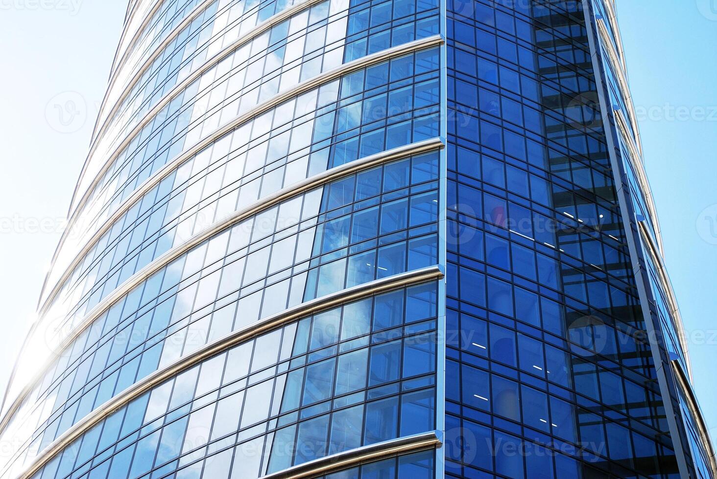 Structural glass wall reflecting blue sky. Abstract modern architecture fragment. photo