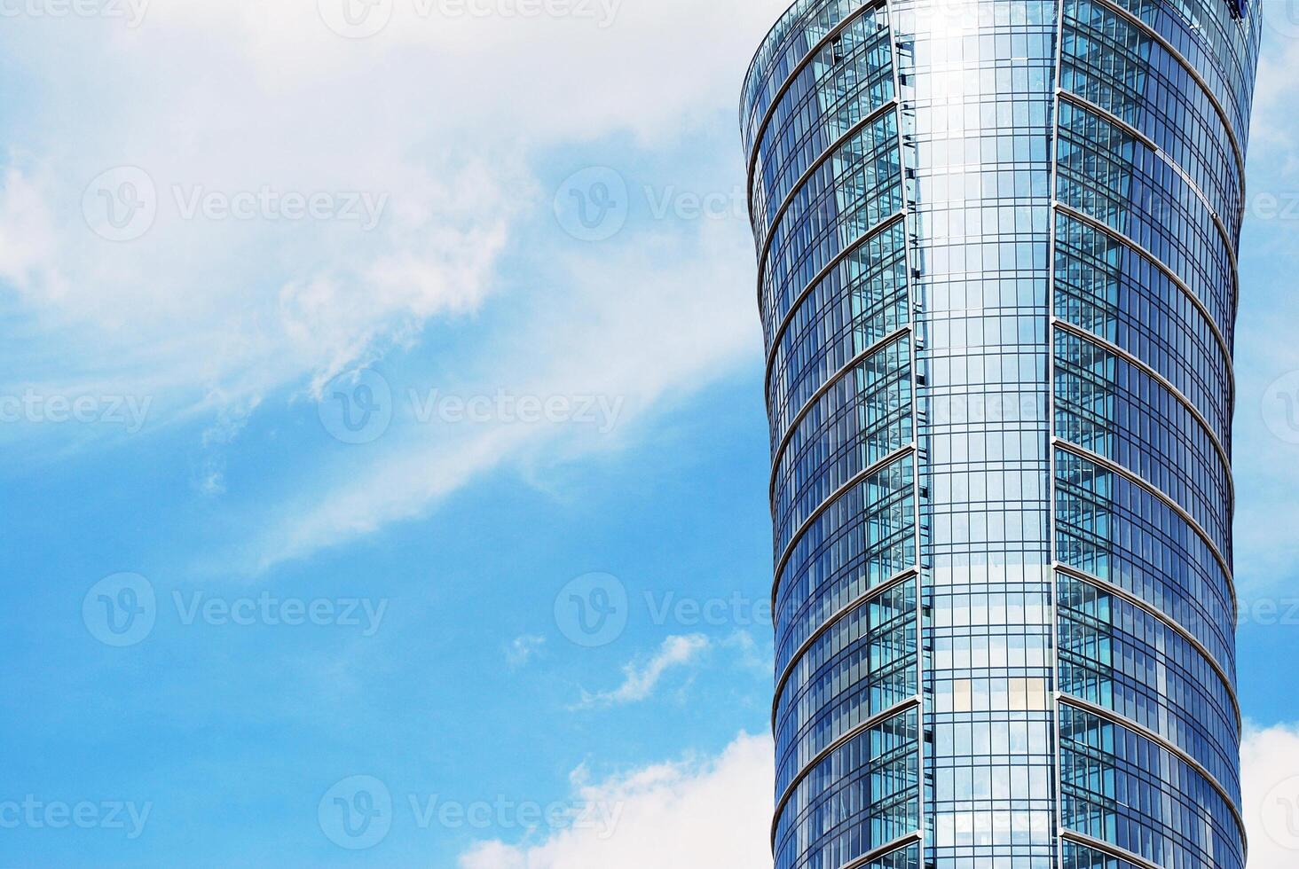 Structural glass wall reflecting blue sky. Abstract modern architecture fragment. photo