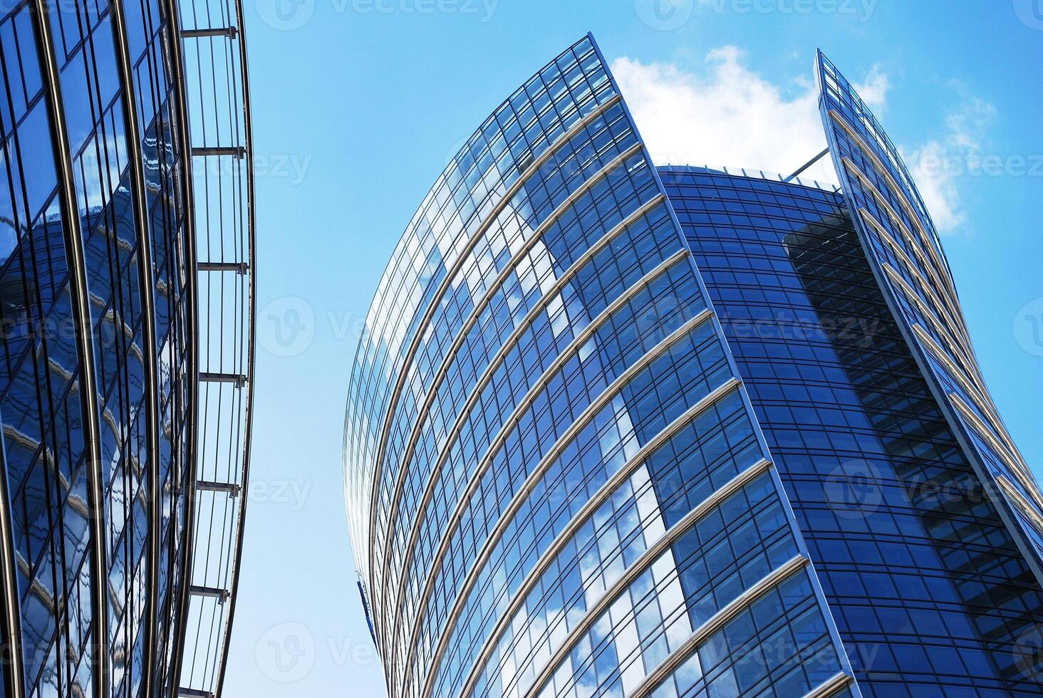 Structural glass wall reflecting blue sky. Abstract modern architecture fragment. photo