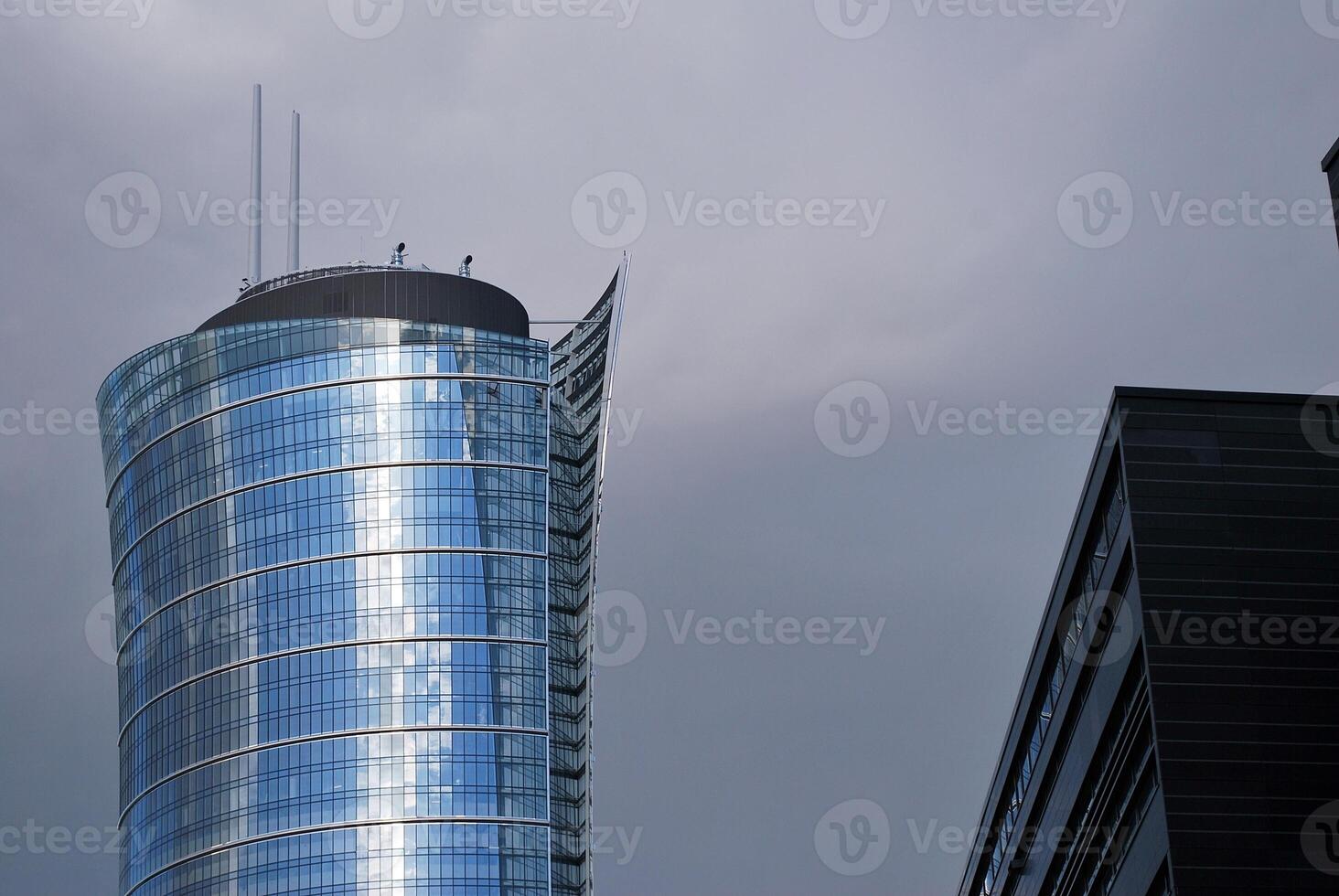 Structural glass wall reflecting blue sky. Abstract modern architecture fragment. photo