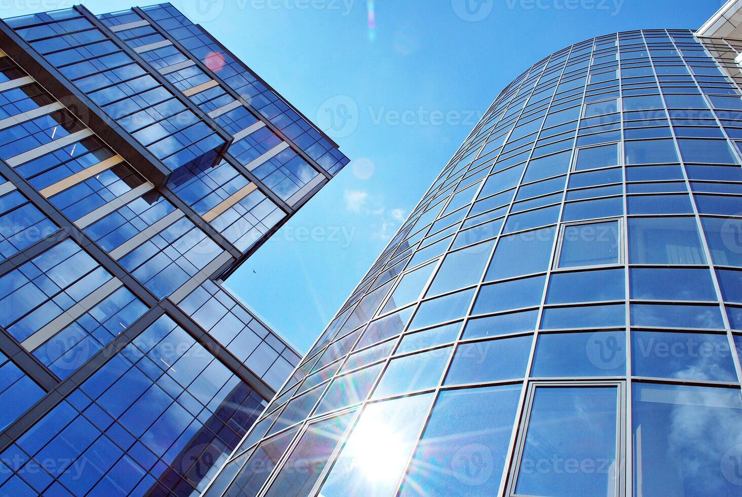 Glass building with transparent facade of the building and blue sky. Structural glass wall reflecting blue sky. Abstract modern architecture fragment. Contemporary architectural background. photo