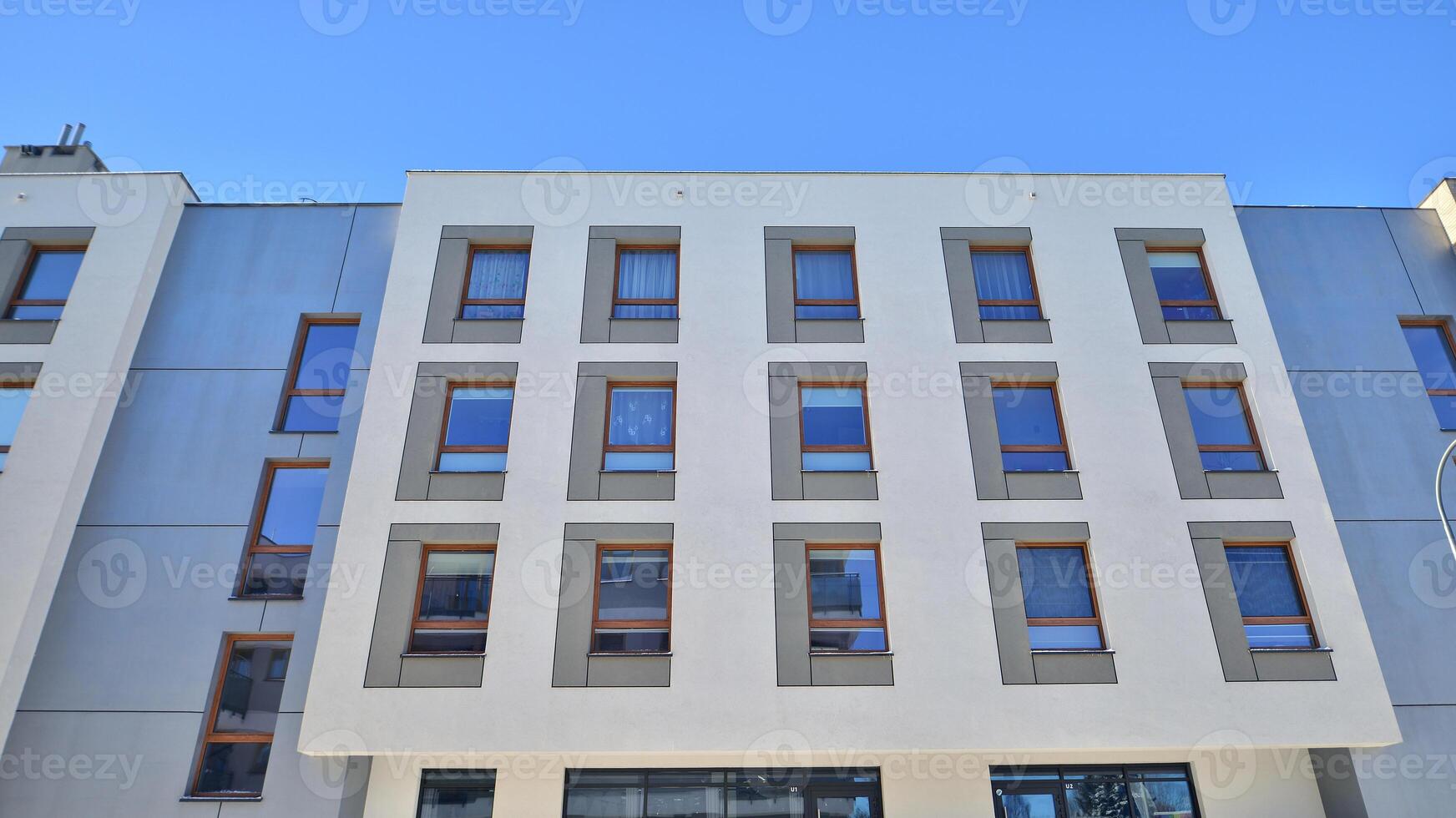 Modern apartment building in sunny day. Exterior, residential house facade. Residential area with modern, new and stylish living block of flats. photo