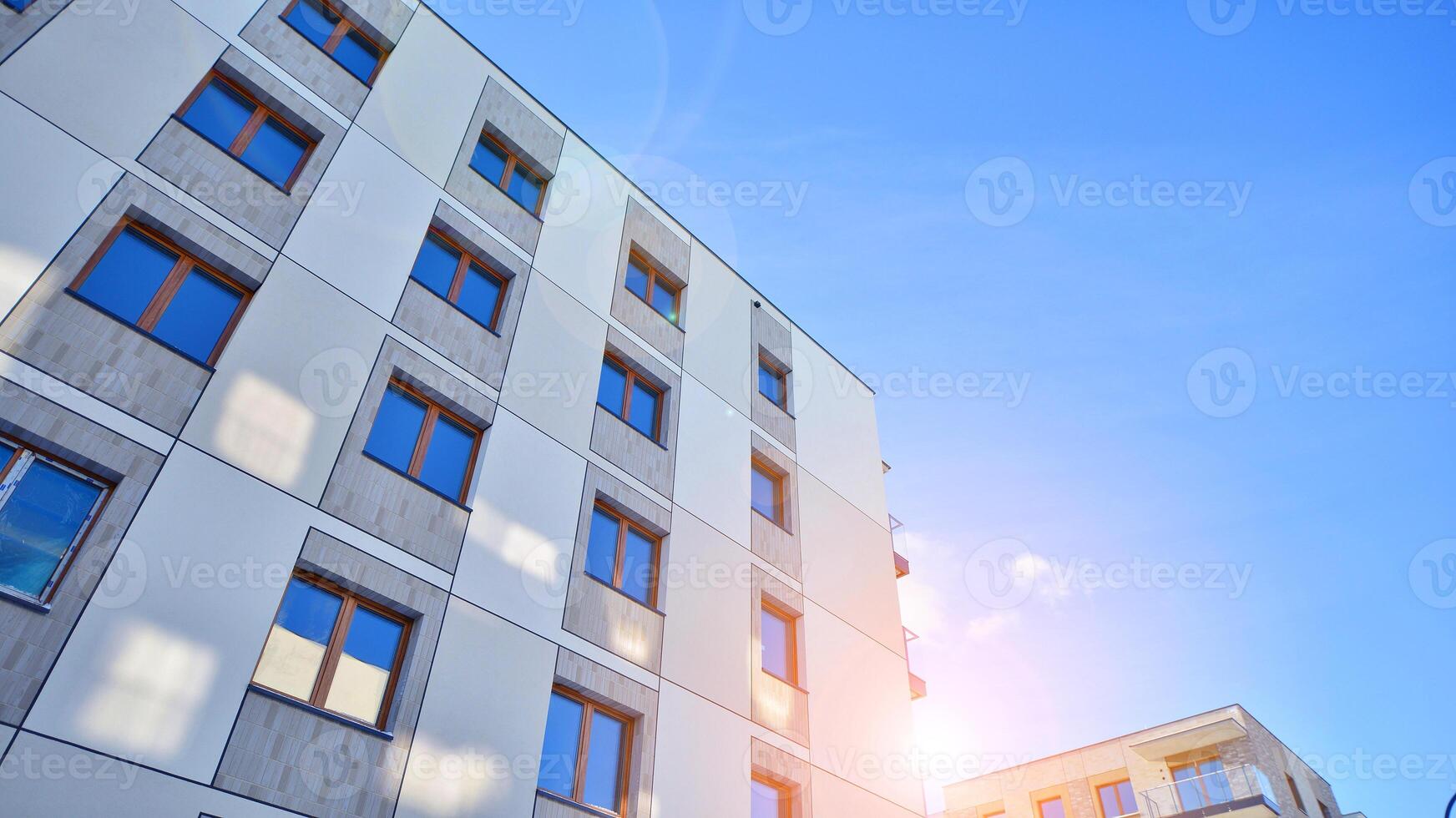 Modern apartment building in sunny day. Exterior, residential house facade. Residential area with modern, new and stylish living block of flats. photo