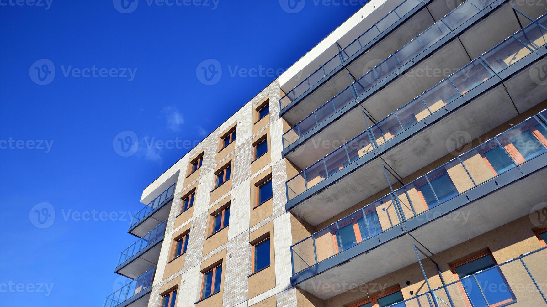 Modern apartment building in sunny day. Exterior, residential house facade. Residential area with modern, new and stylish living block of flats. photo