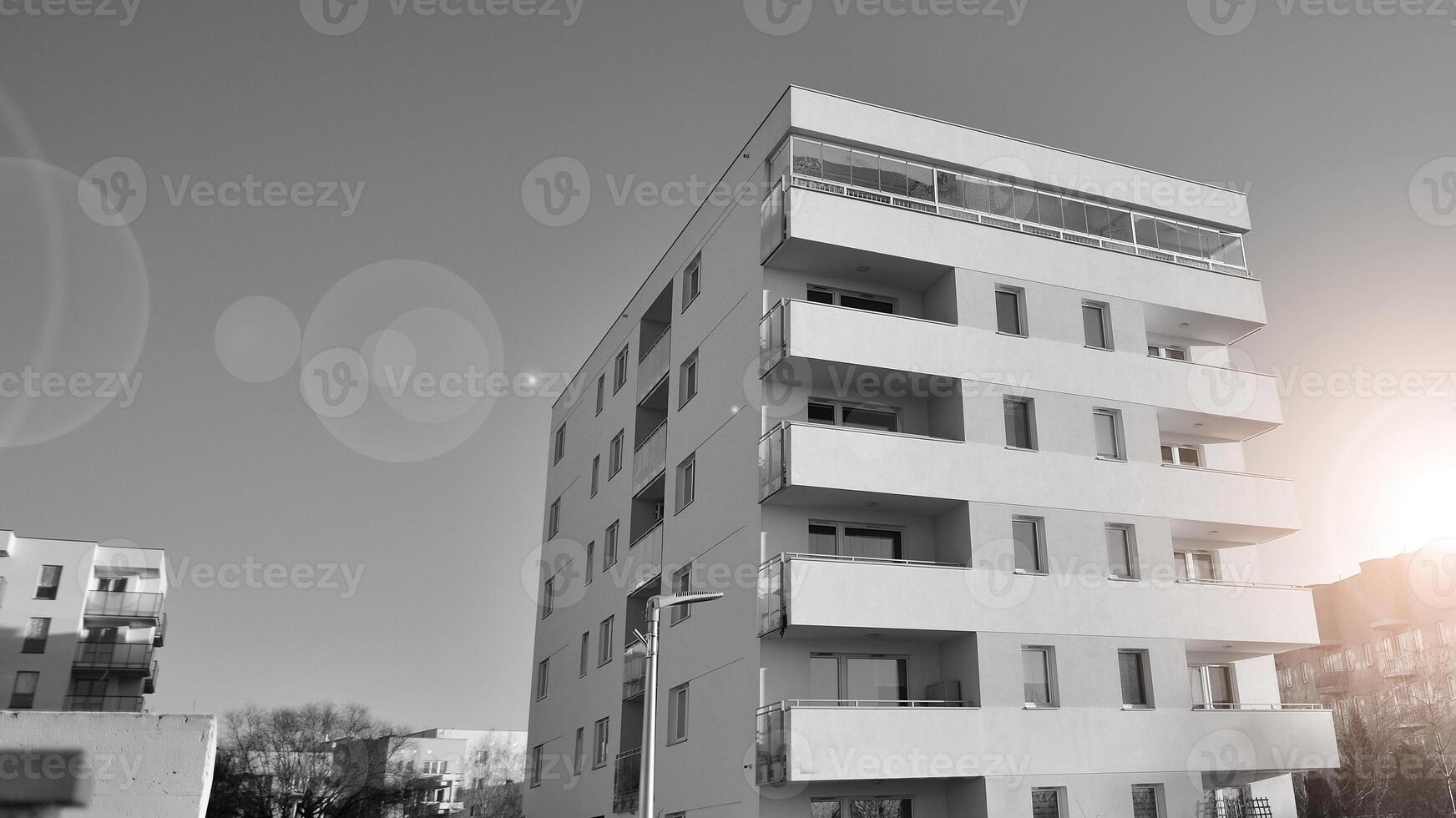 Fragment of the building's facade with windows and balconies. Modern apartment buildings on a sunny day. Facade of a modern residential building. Black and white. photo