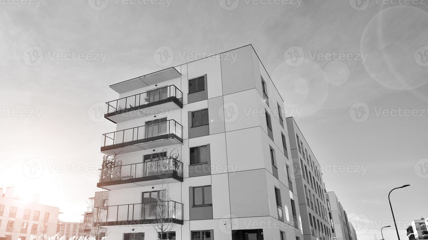 Fragment of the building's facade with windows and balconies. Modern apartment buildings on a sunny day. Facade of a modern residential building. Black and white. photo