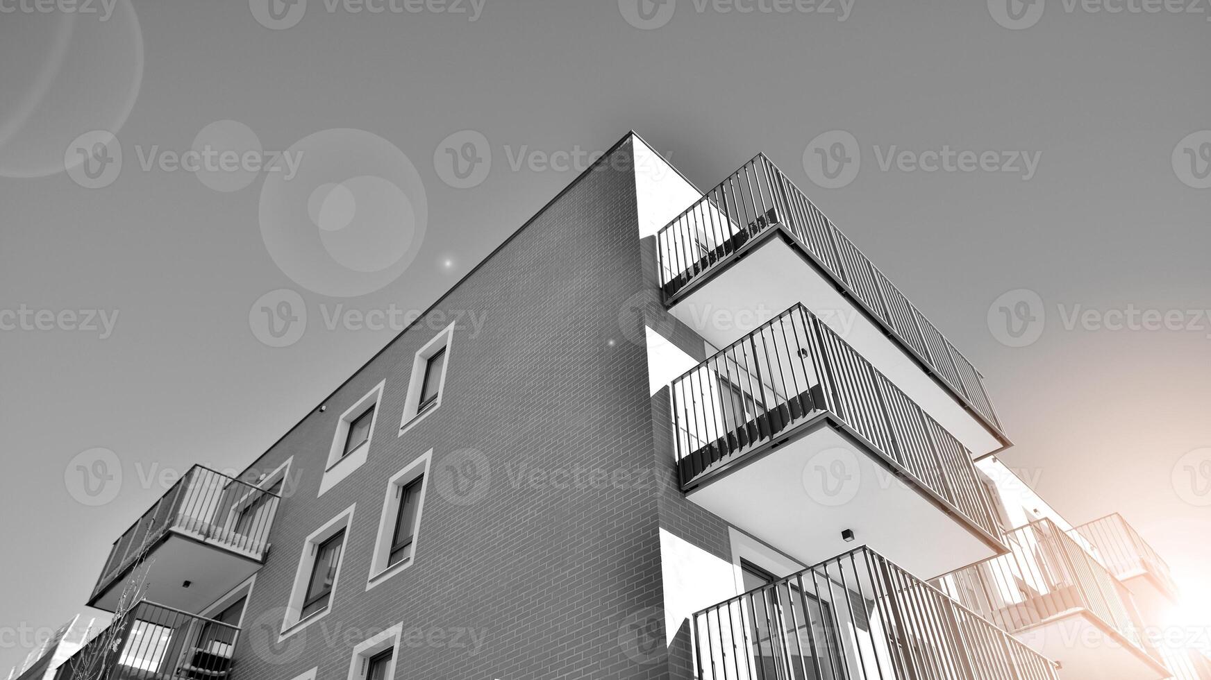 Fragment of the building's facade with windows and balconies. Modern apartment buildings on a sunny day. Facade of a modern residential building. Black and white. photo