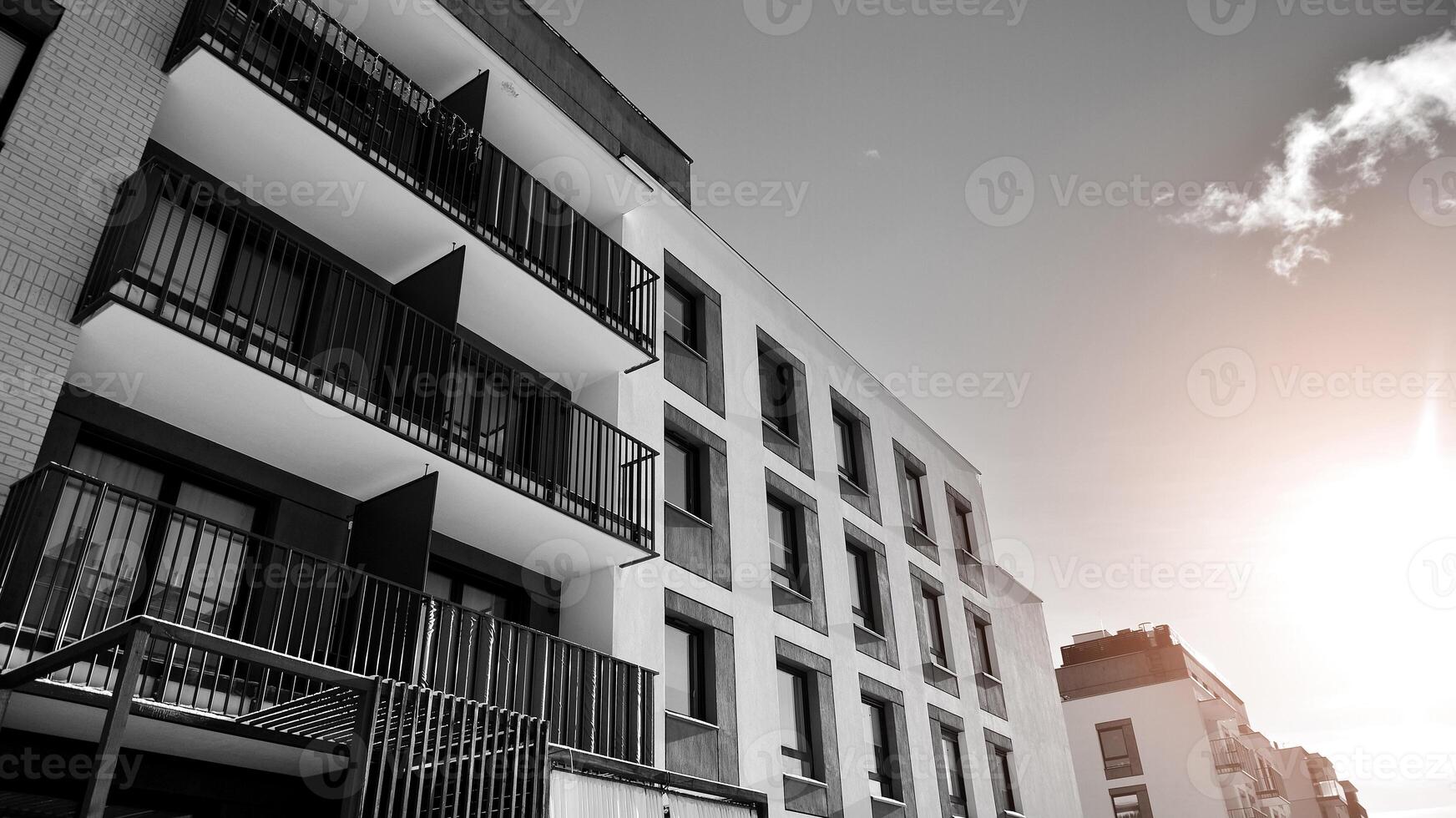 Fragment of the building's facade with windows and balconies. Modern apartment buildings on a sunny day. Facade of a modern residential building. Black and white. photo