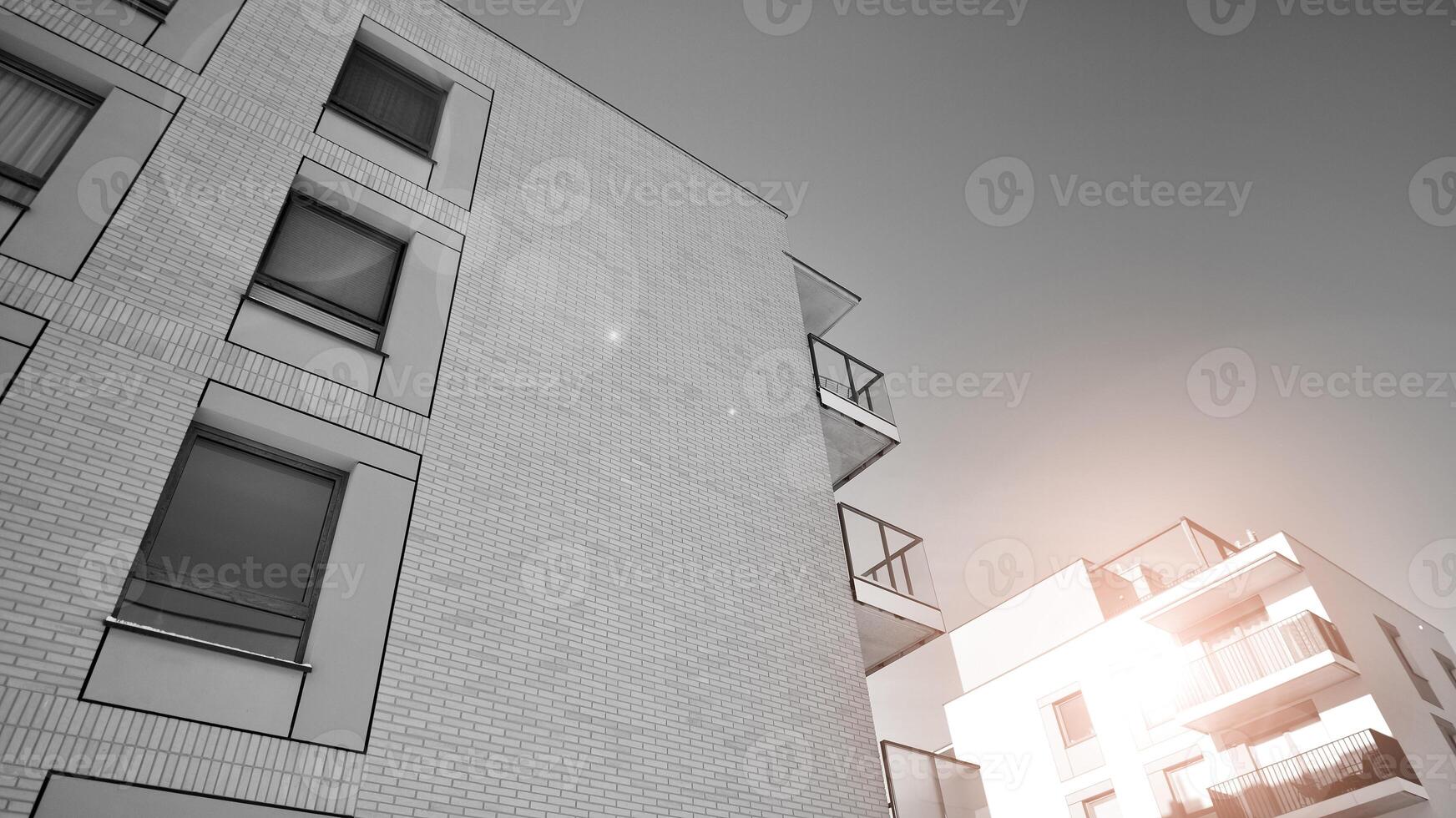 Fragment of the building's facade with windows and balconies. Modern apartment buildings on a sunny day. Facade of a modern residential building. Black and white. photo