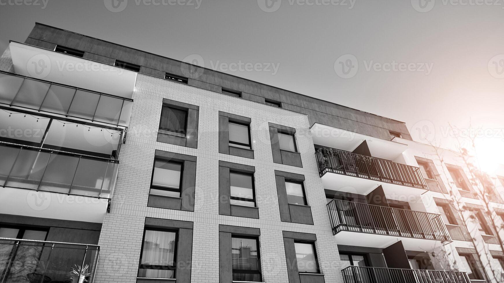 Fragment of the building's facade with windows and balconies. Modern apartment buildings on a sunny day. Facade of a modern residential building. Black and white. photo
