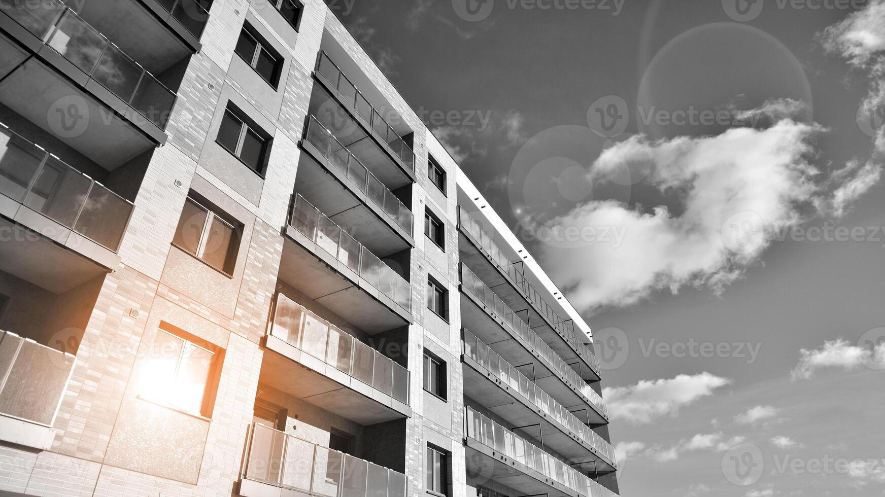 Fragment of the building's facade with windows and balconies. Modern apartment buildings on a sunny day. Facade of a modern residential building. Black and white. photo