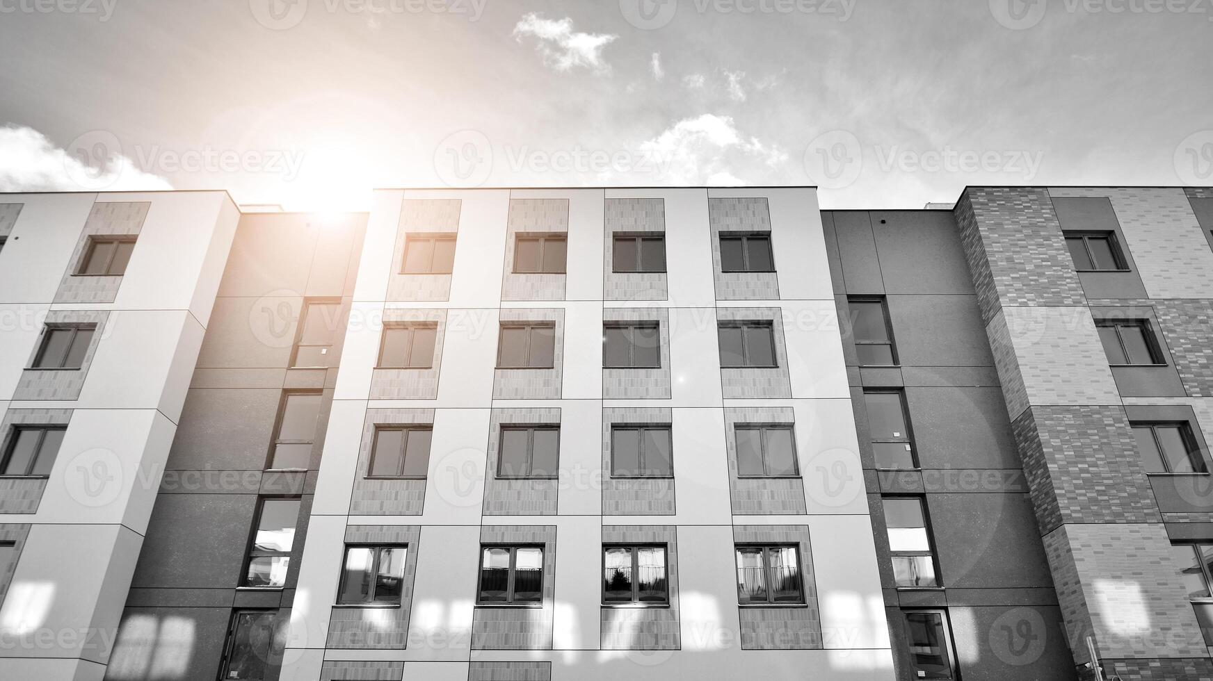 Fragment of the building's facade with windows and balconies. Modern apartment buildings on a sunny day. Facade of a modern residential building. Black and white. photo