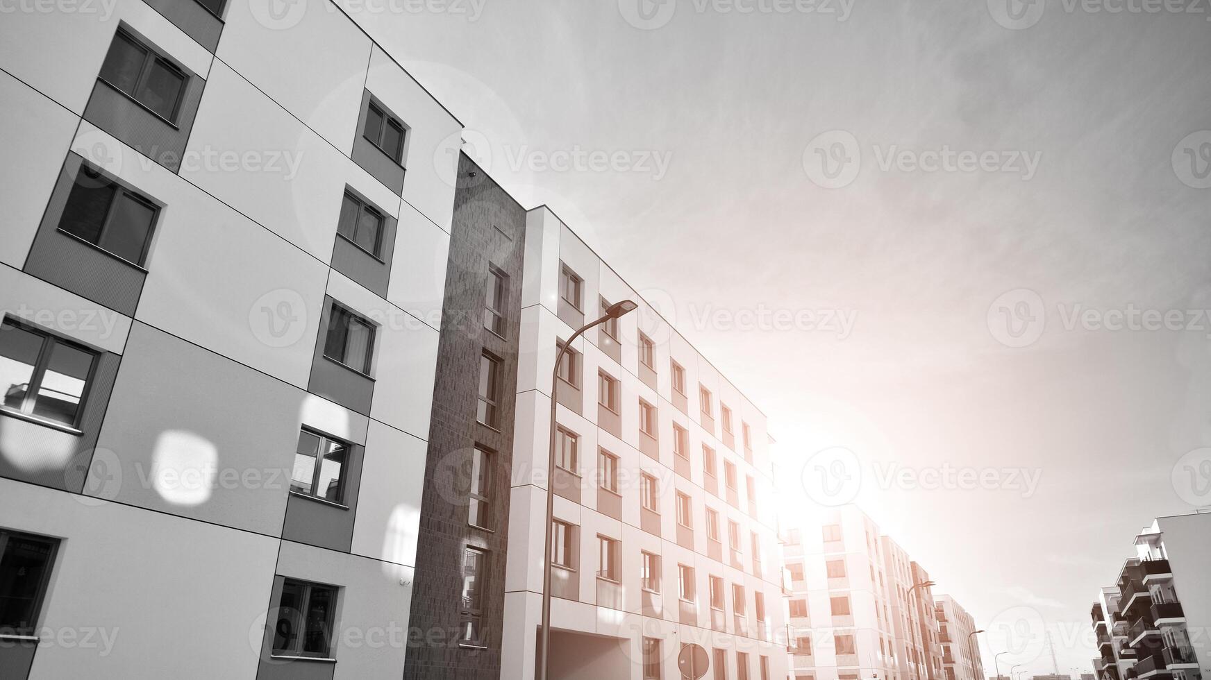 Fragment of the building's facade with windows and balconies. Modern apartment buildings on a sunny day. Facade of a modern residential building. Black and white. photo