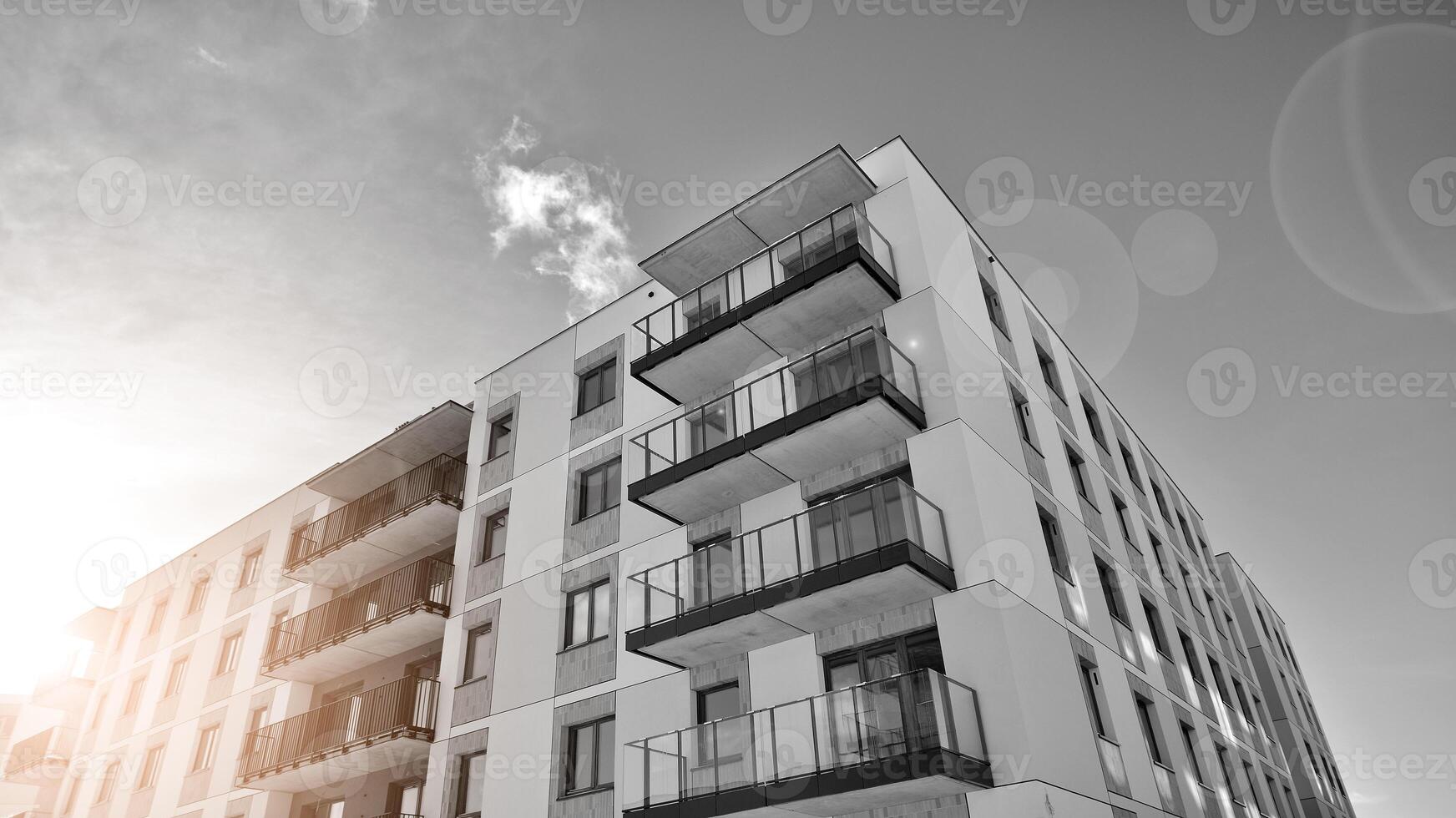 Fragment of the building's facade with windows and balconies. Modern apartment buildings on a sunny day. Facade of a modern residential building. Black and white. photo