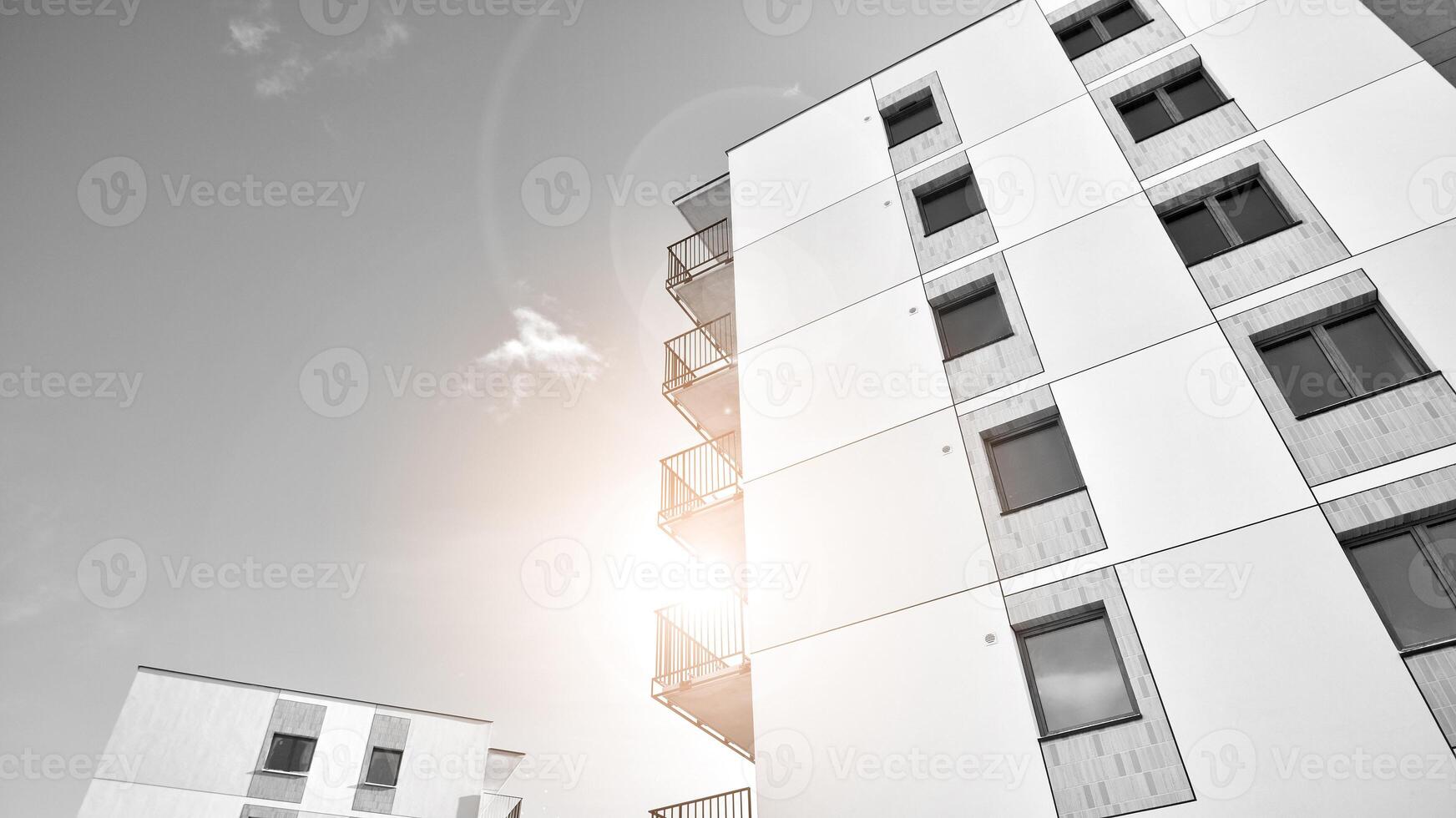 Fragment of the building's facade with windows and balconies. Modern apartment buildings on a sunny day. Facade of a modern residential building. Black and white. photo